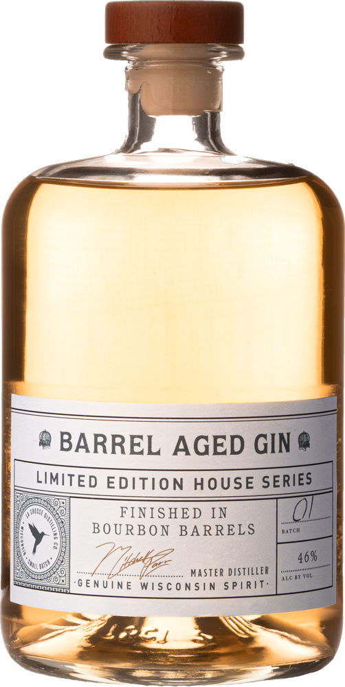 A bottle of Barrel Aged Gin with a wooden cap and a label indicating it is bourbon barrel finished, 46% alcohol by volume, part of a limited edition house series.