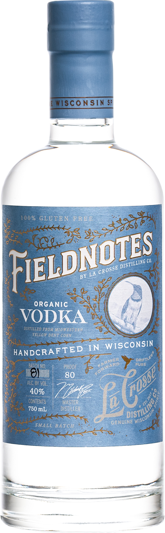 A clear glass bottle of Fieldnotes organic vodka with a blue label and matching blue cap, featuring gold accents, a bird illustration, and text indicating it is gluten free, handcrafted in Wisconsin, and made from yellow dent corn.