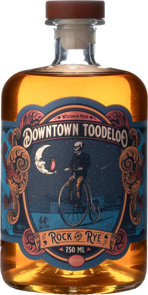 Bottle of Downtown Toodledo with organic Rock and Rye flavor, featuring a label with a skeleton riding a bicycle under a starry sky near the moon in Wisconsin.