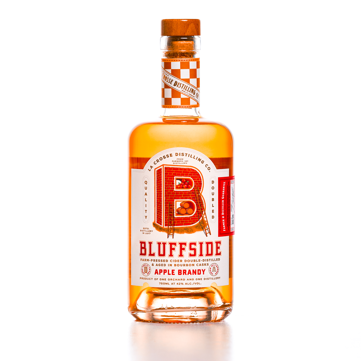 Bottle of Bluffside Apple Brandy with orange-tinted liquid and a label featuring a large red brick letter 'B' and red text.