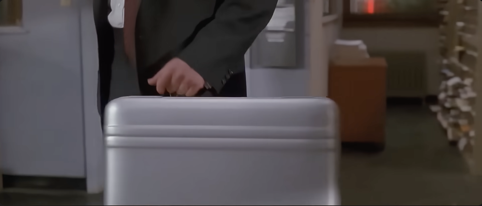 Alec Baldwin behind his aluminum briefcase in Glengarry Glen Ross