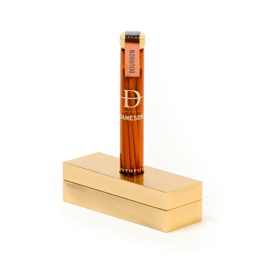 A Daneson toothpick vial on a brushed gold tabletop display