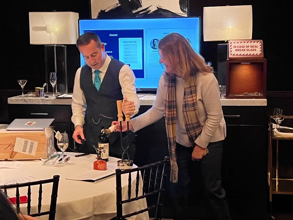 A dinner guest is using a shaving brush to initiate thermal shock on a vintage bottle of Port