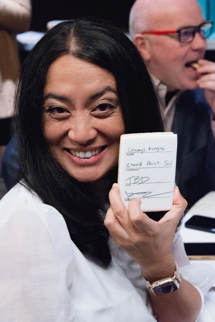 A guest holding up a sugar cookie "form" that they filled out with an edible pen