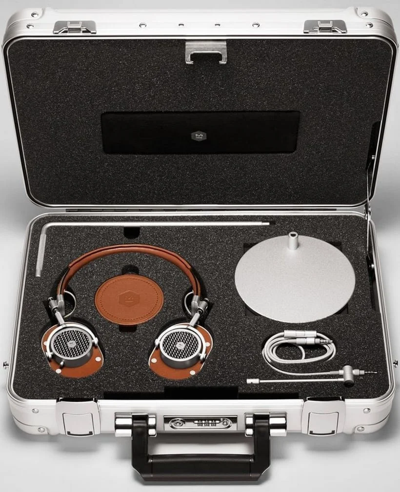 A pair of Master & Dynamic headphones and accessories in a custom foam insert inside a Zero Halliburton briefcase