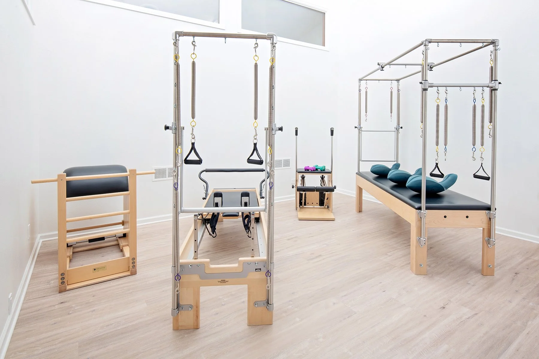 Taylor Pilates & Fitness studio image showing the many type of equipment used, including, the Pilates trapeze table, the Wunda Chair, and Pilates Reformer.
