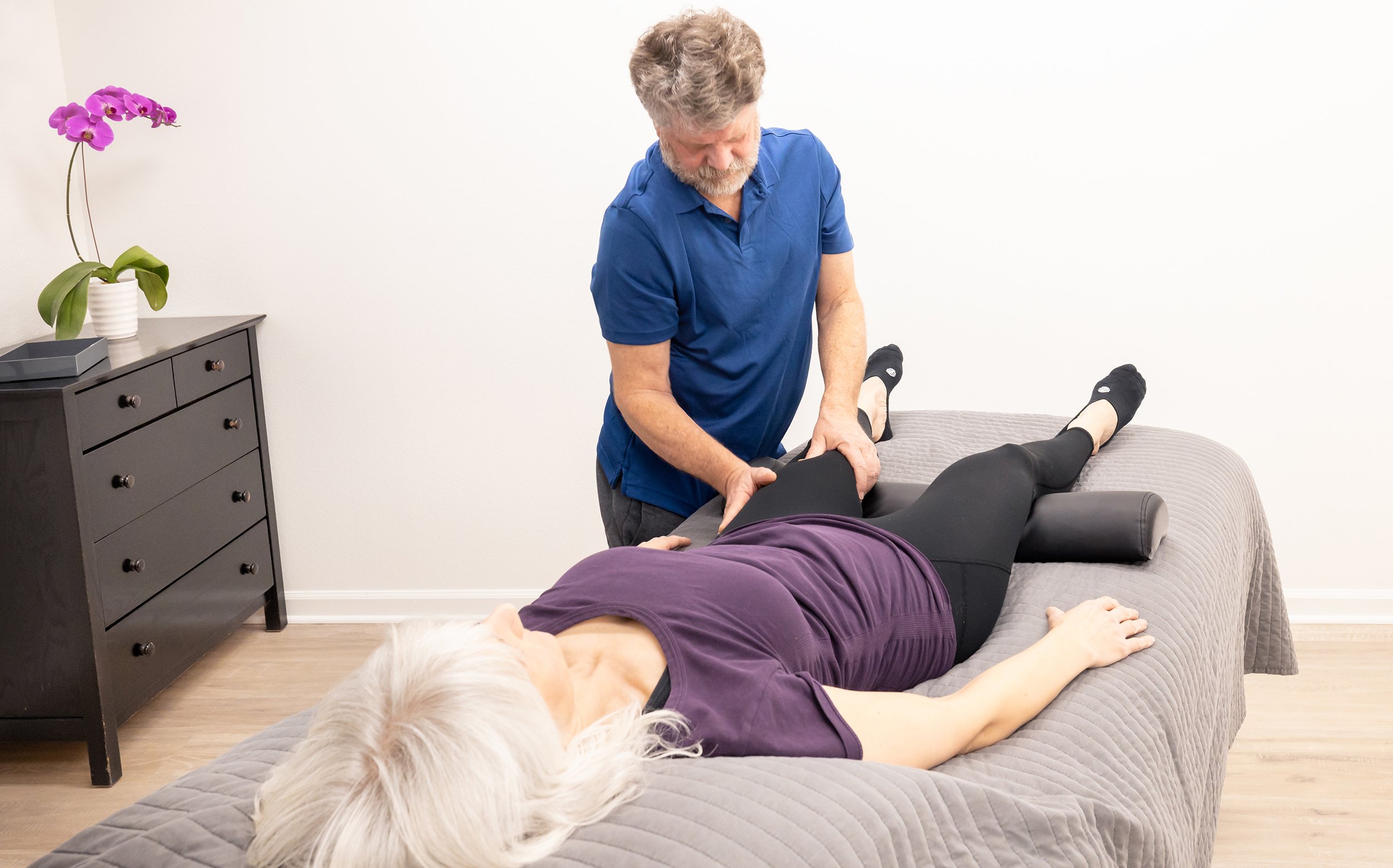 Andrew Kerr, Myofascial Release & Physical Therapist at Taylor Pilates & Fitness, working with a client on the massage table.