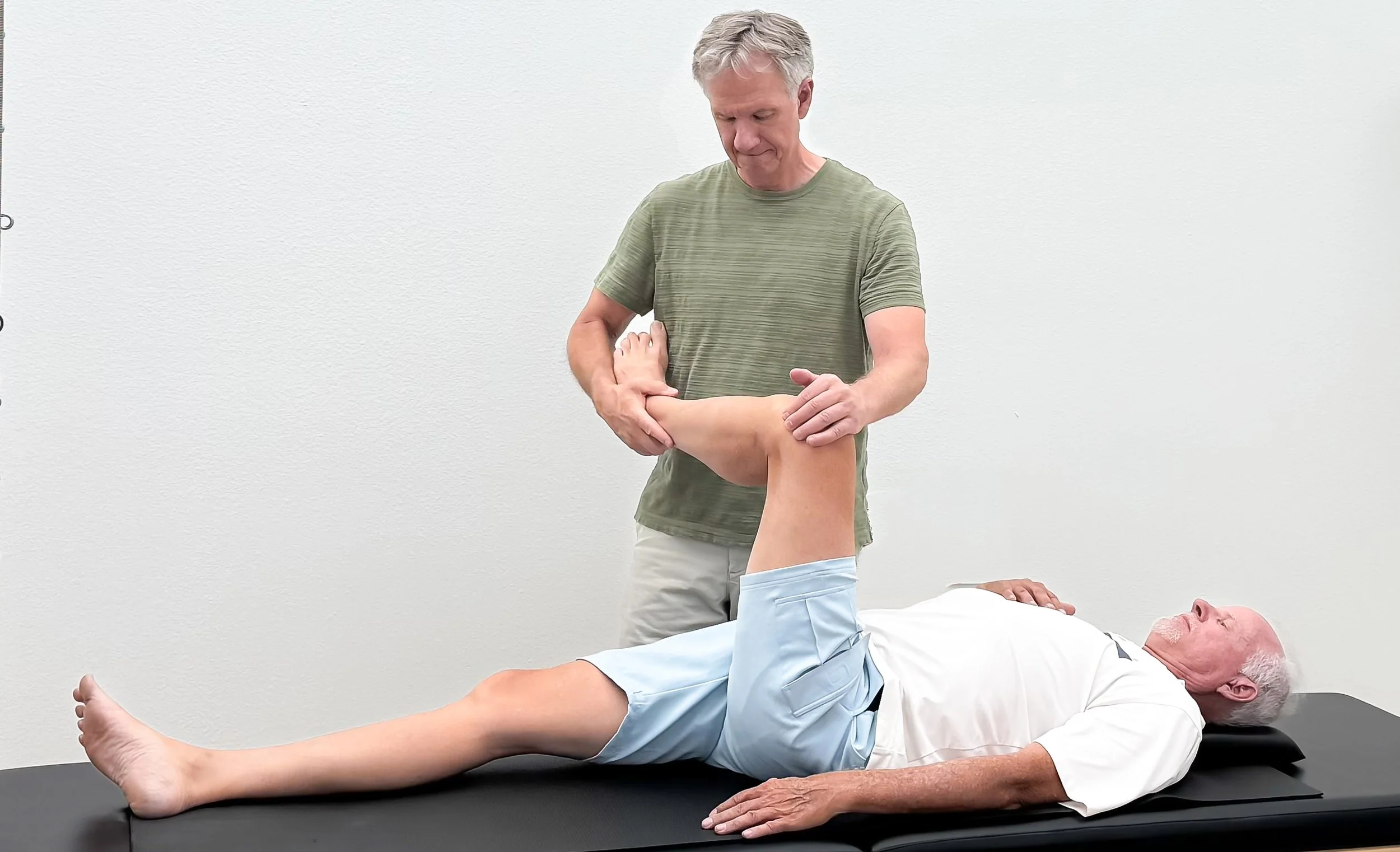 Michael Mathews, Movement Practitioner & Acupuncturist at Taylor Pilates & Fitness, working with a rehab client on the Pilates trapeze table