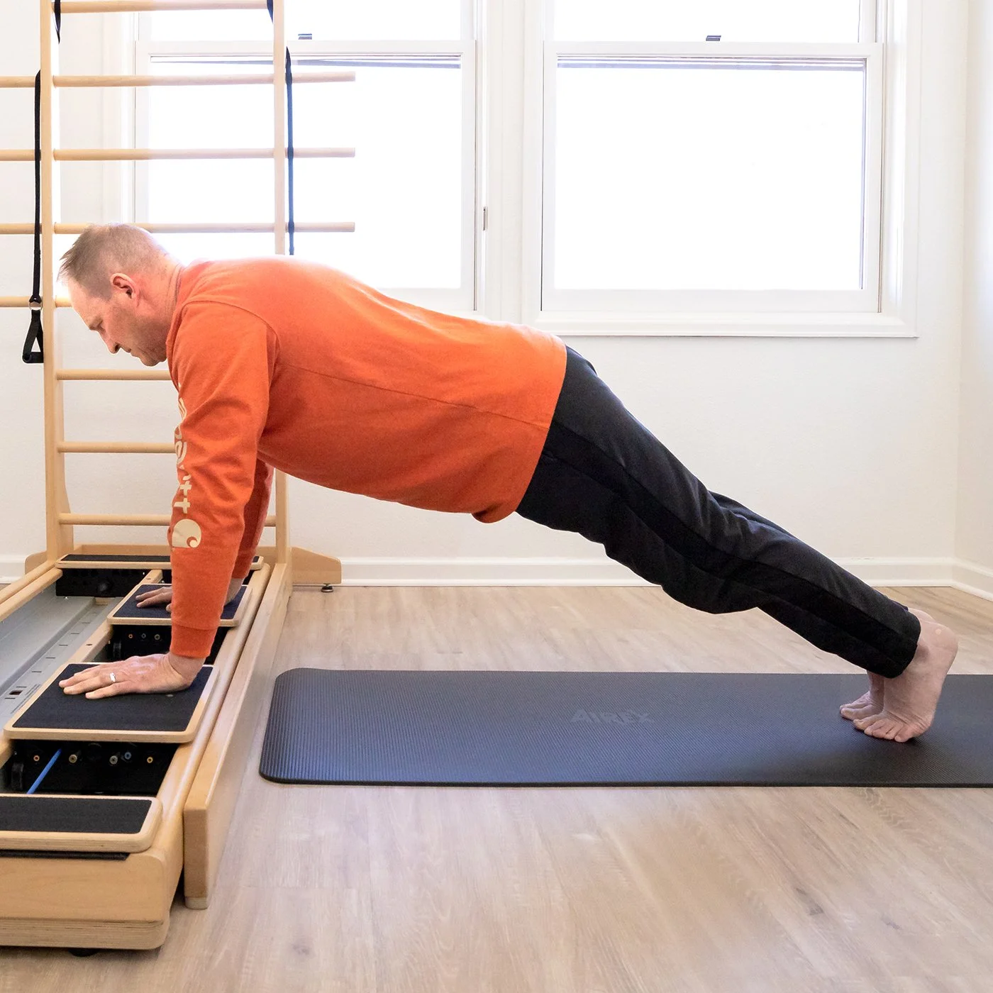 A Taylor Pilates & Fitness client working on the CoreAlign, an exercise and rehabilitation device that features a frame with two independent, smoothly moving carts on dual tracks.