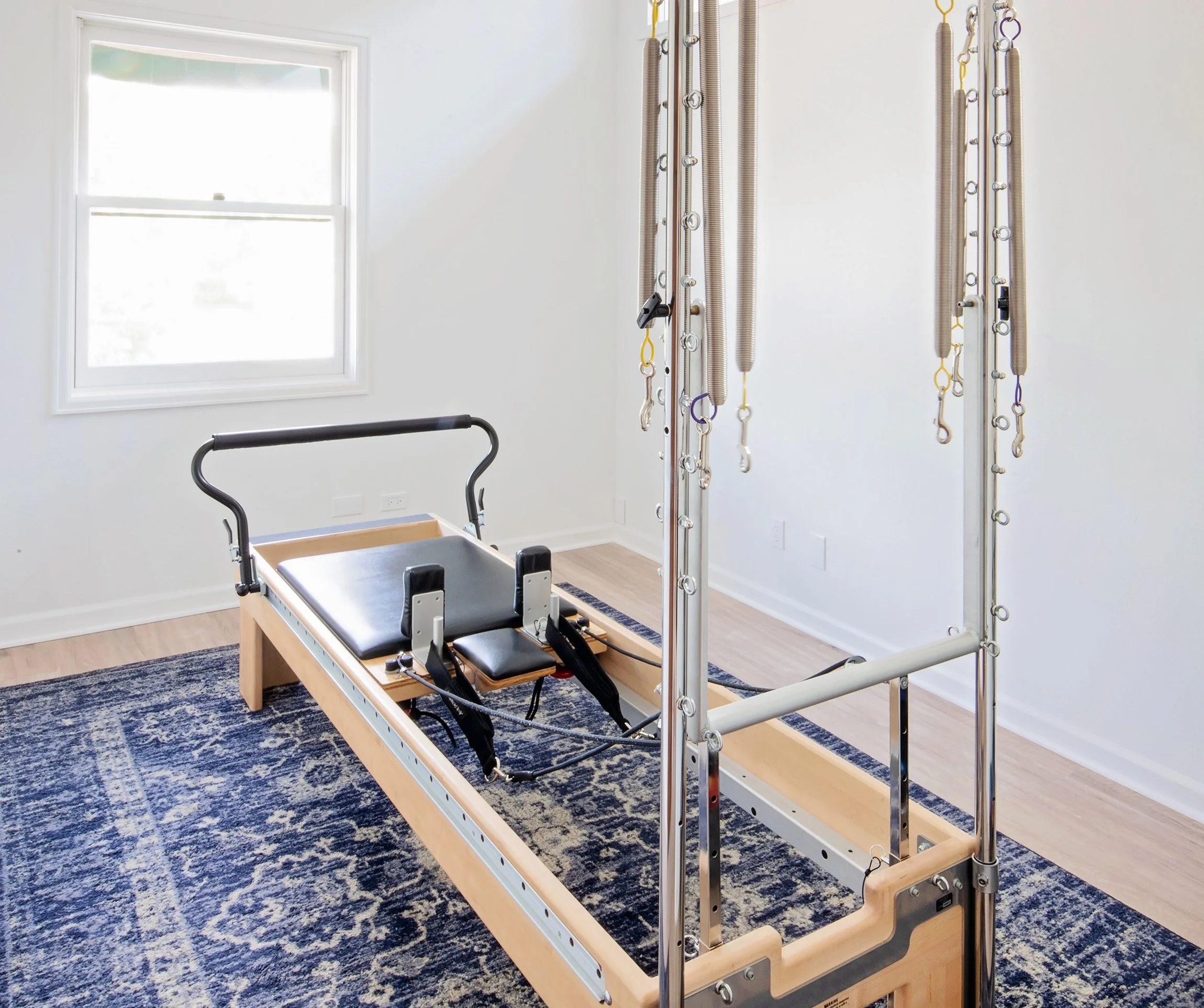 Taylor Pilates & Fitness studio image showing the many type of equipment used, including, the Pilates trapeze table, the Wunda Chair, and Pilates Reformer.