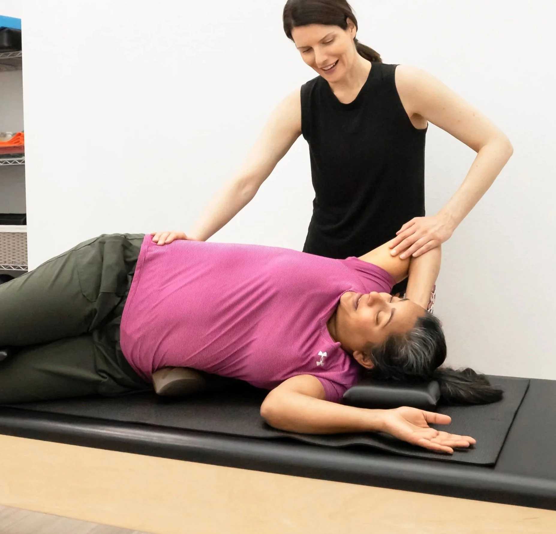 A Taylor Pilates & Fitness movement practitioner working with a client for rehabbing an injury on the trapeze table during a private pilates session.