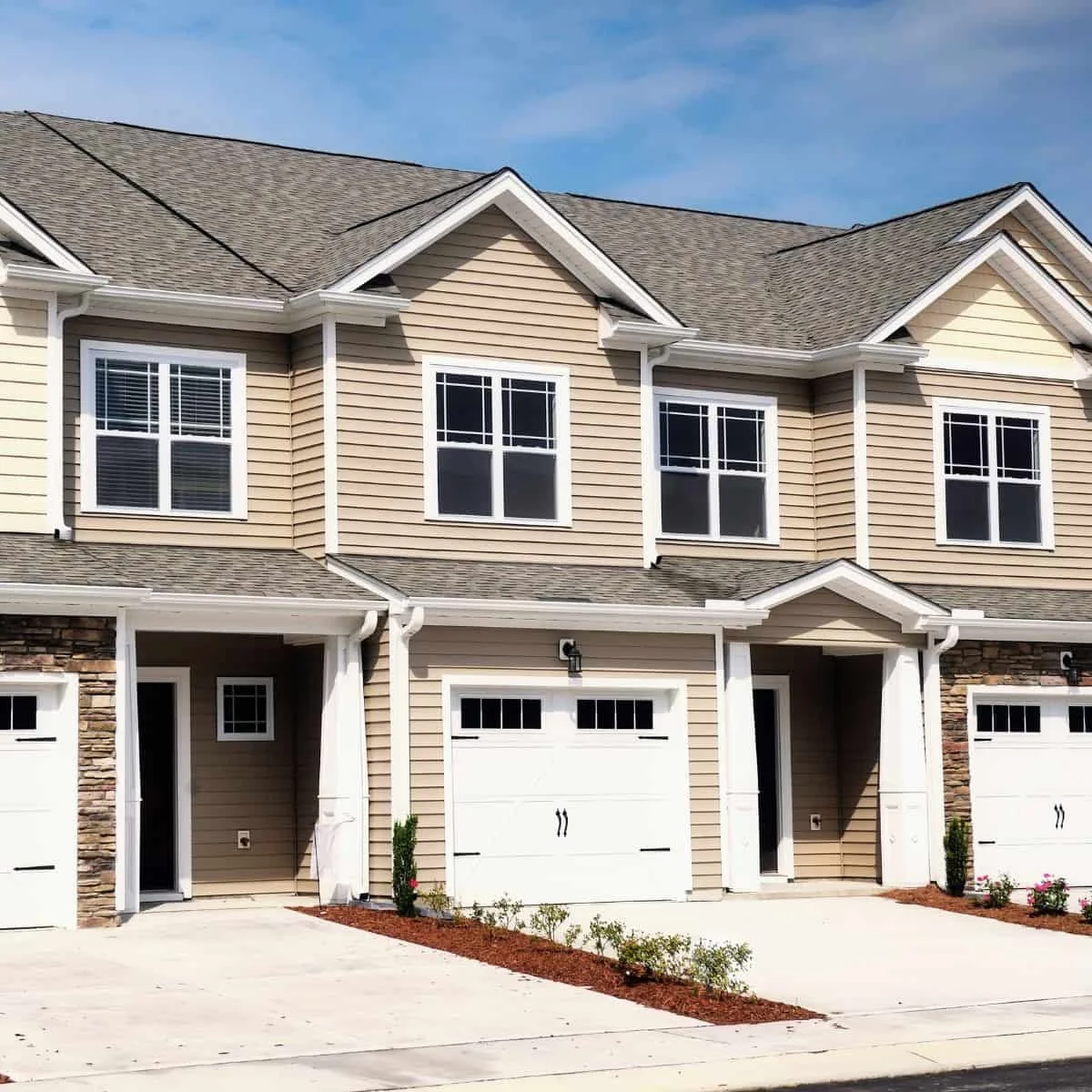 a row of town homes with garages and front doors