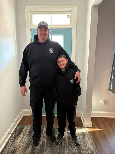 Alan Carr and son in a hallway