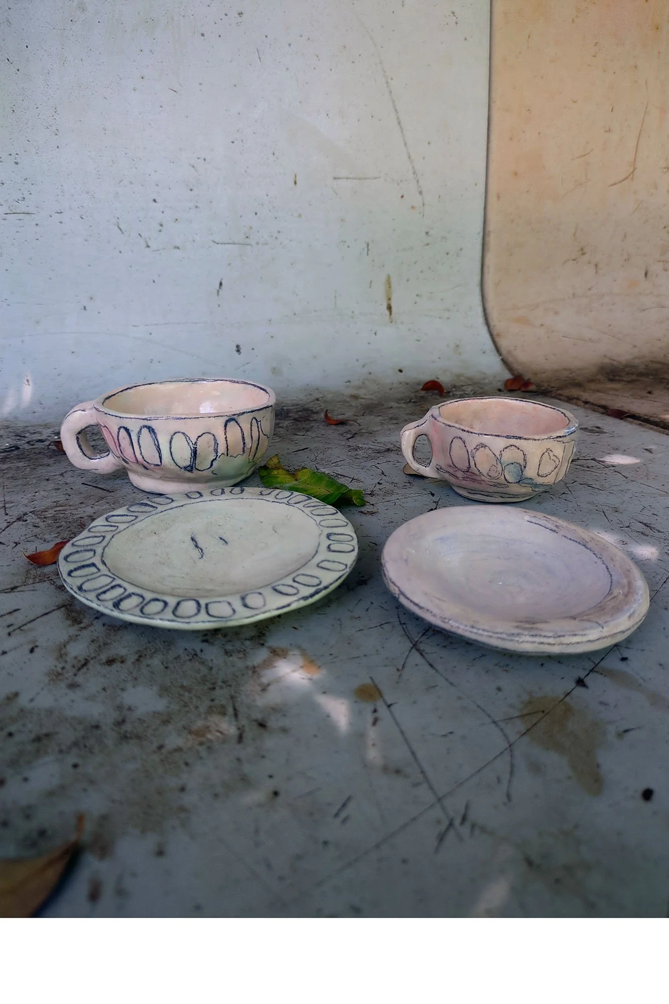 Large and small porcelain cup separated from their saucers, showing grooved exterior detail