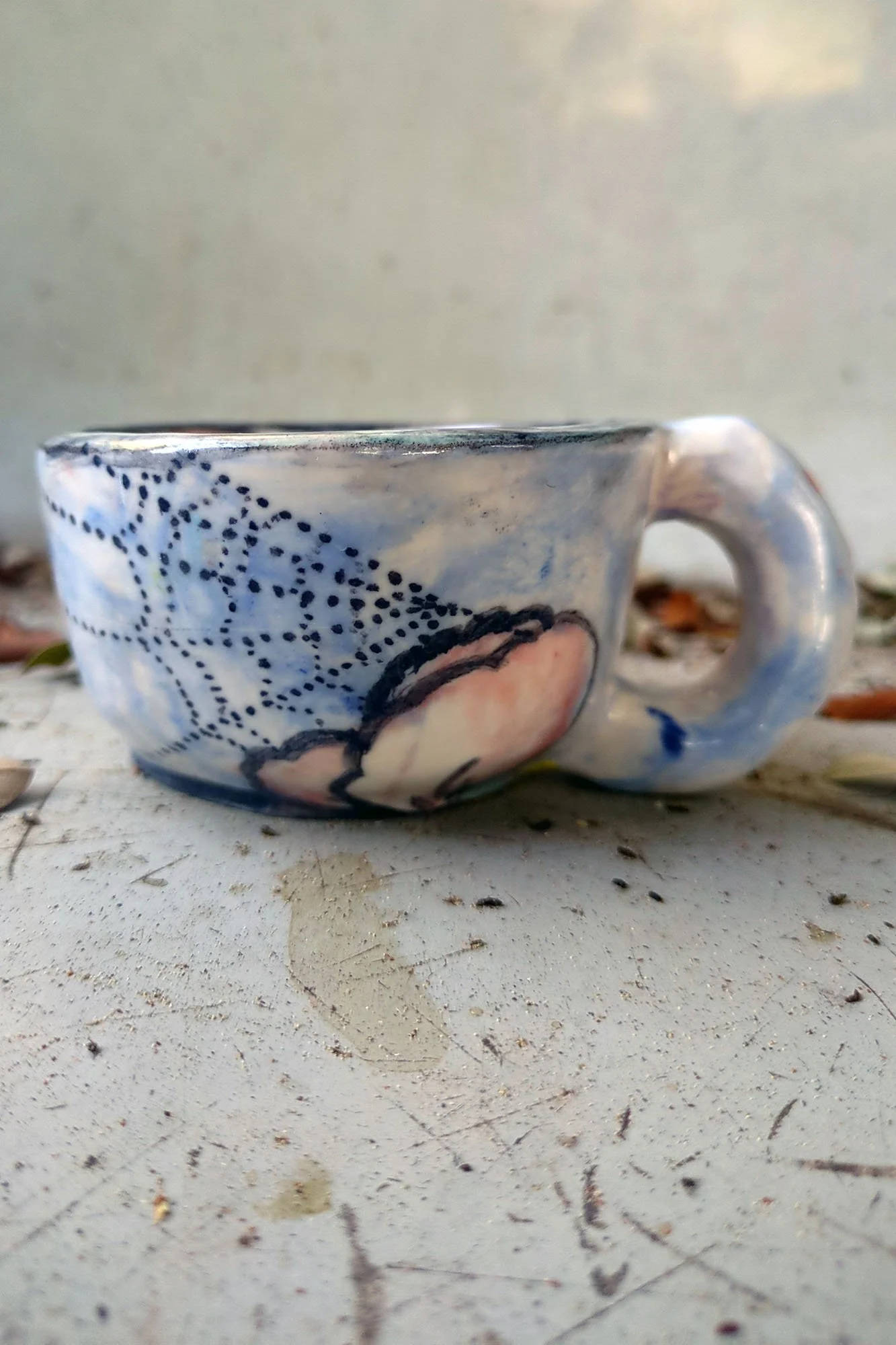johanna-jackson-canted-cup-web-flower-front.jpg One of a kind ceramic cup by Johanna Jackson showing dotted spider web and pink flower on white blue glaze