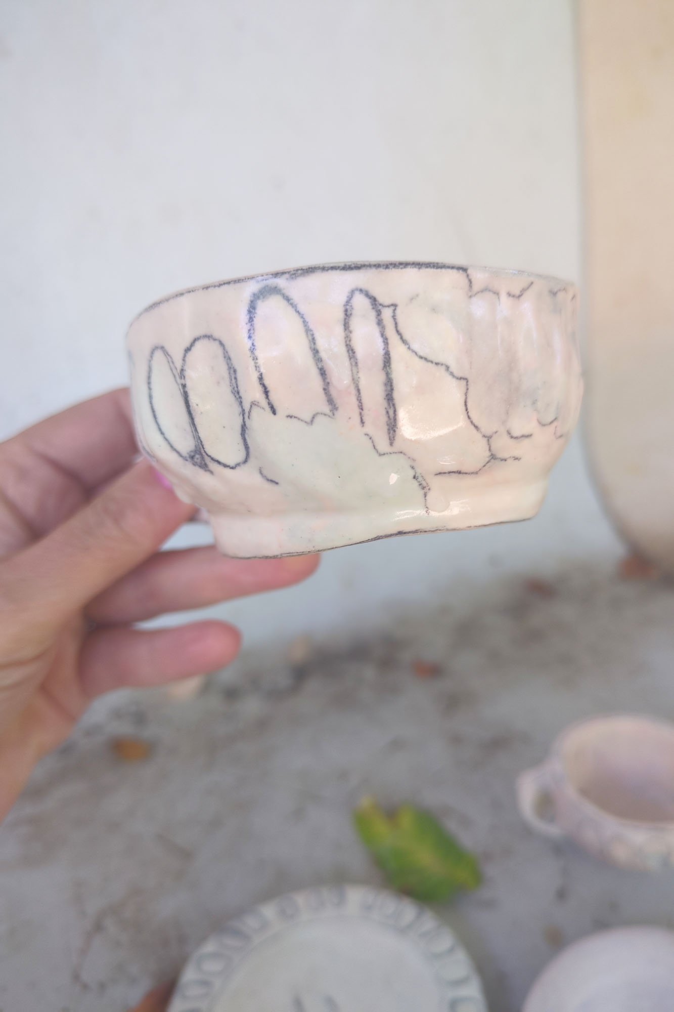 Large studio porcelain cup held in hand to show scale, warm pink, soft glaze