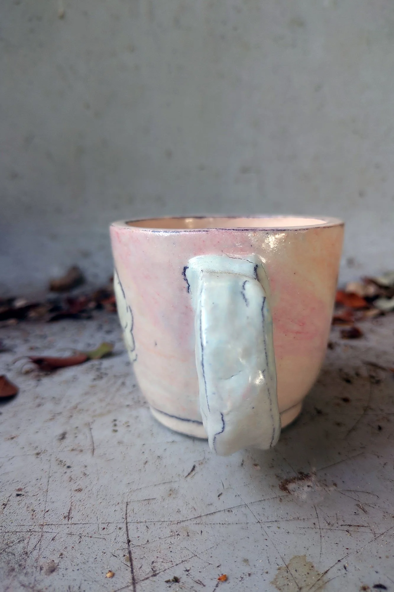 Johanna Jackson ceramic cup handle detail, white sculptural handle against warm pink porcelain body