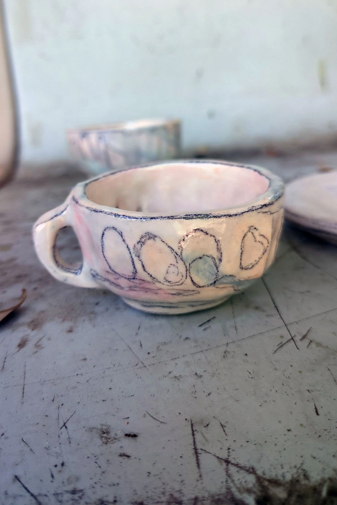 Small studio porcelain cup alone, side view, arch and oval motif band