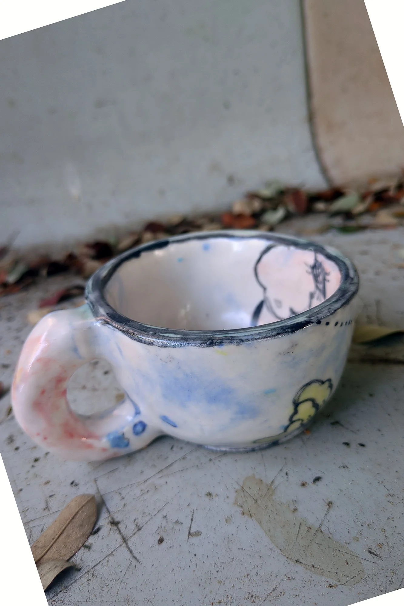 One of a kind ceramic cup by Johanna Jackson seen from above, flower painted inside, blue speckled glaze