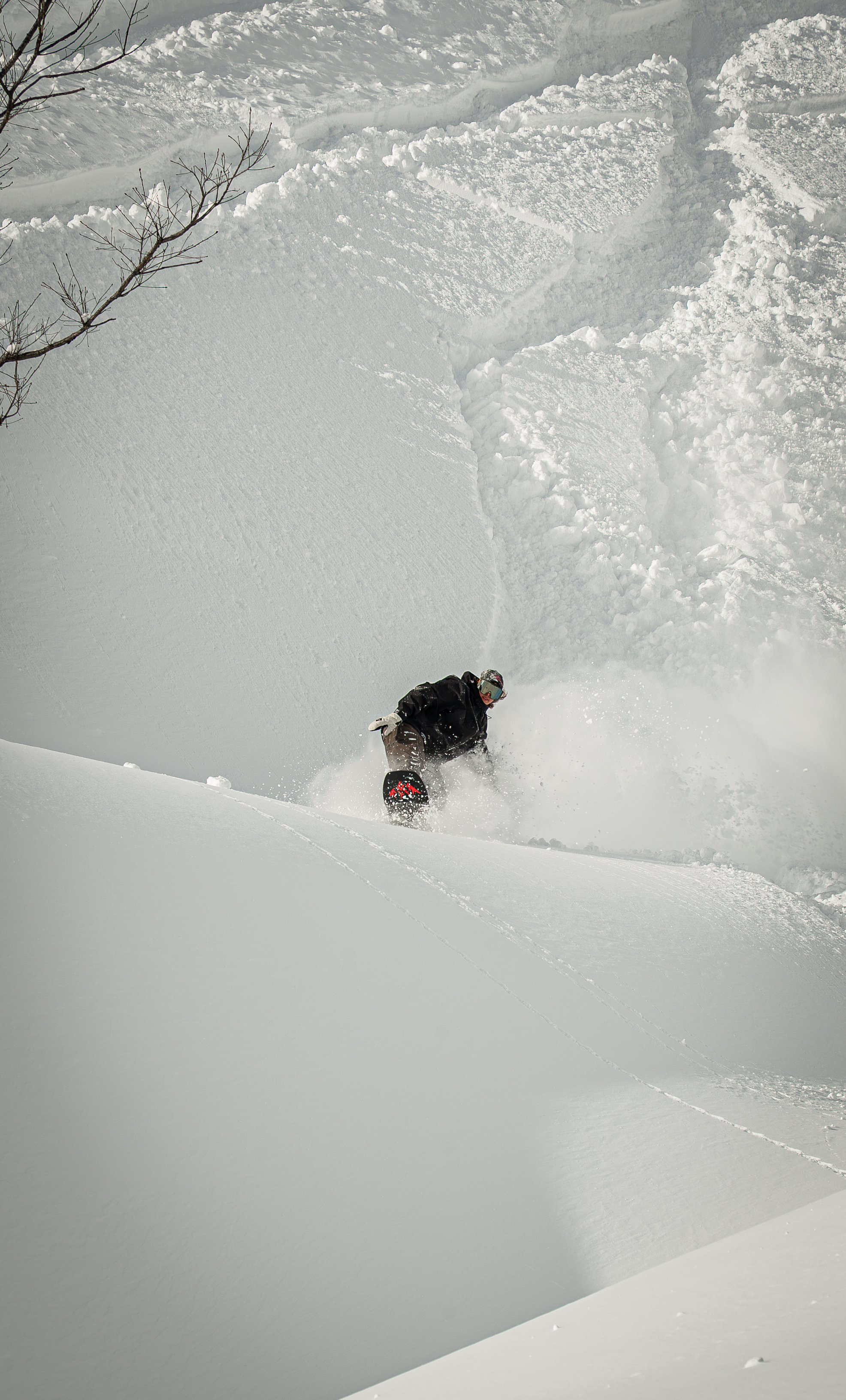 A person snowboarding down a snowy slope in a winter landscape.