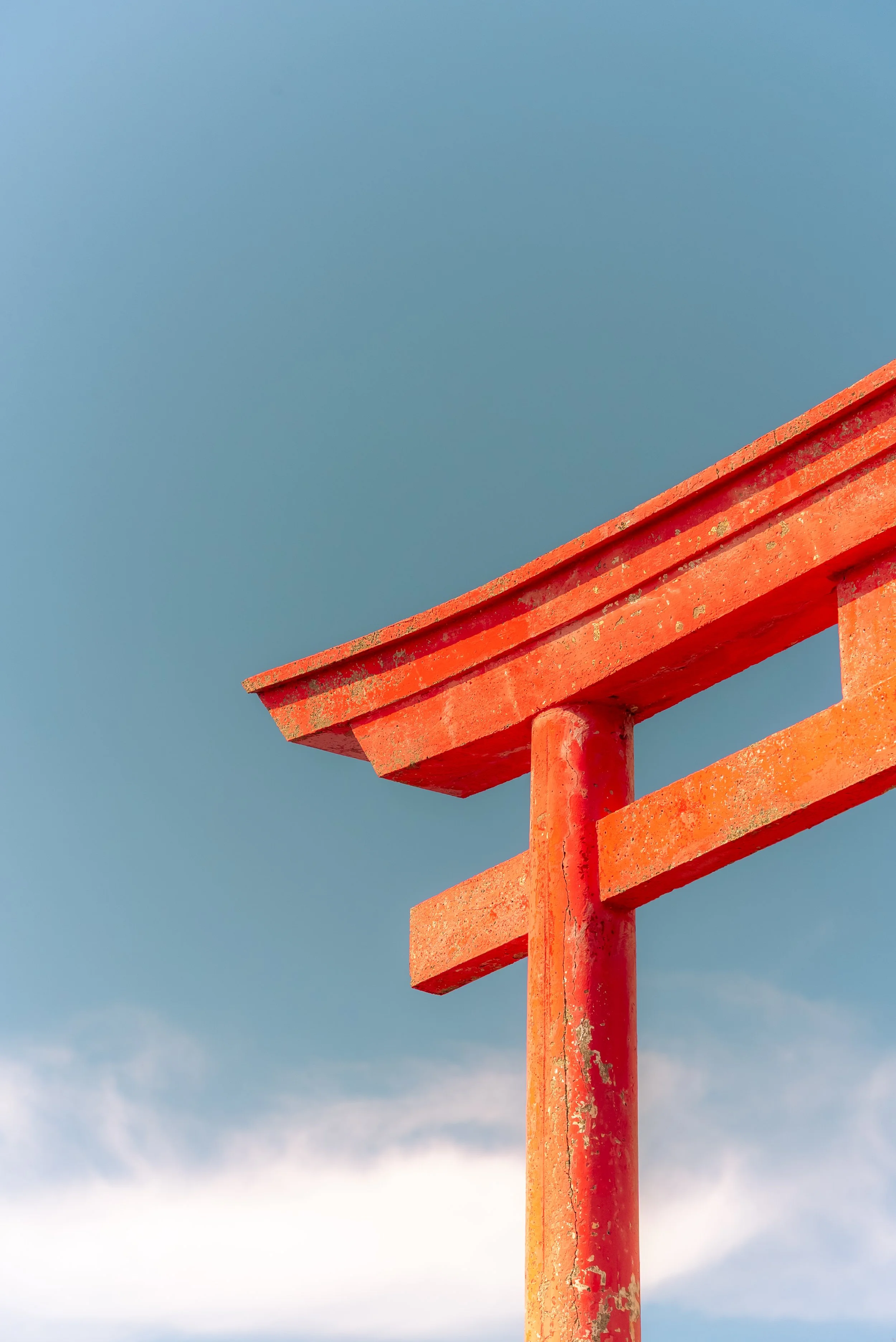Close-up of a red-Colored wooden structure against a blue sky with some clouds, possibly part of a lifeguard tower or similar outdoor structure.