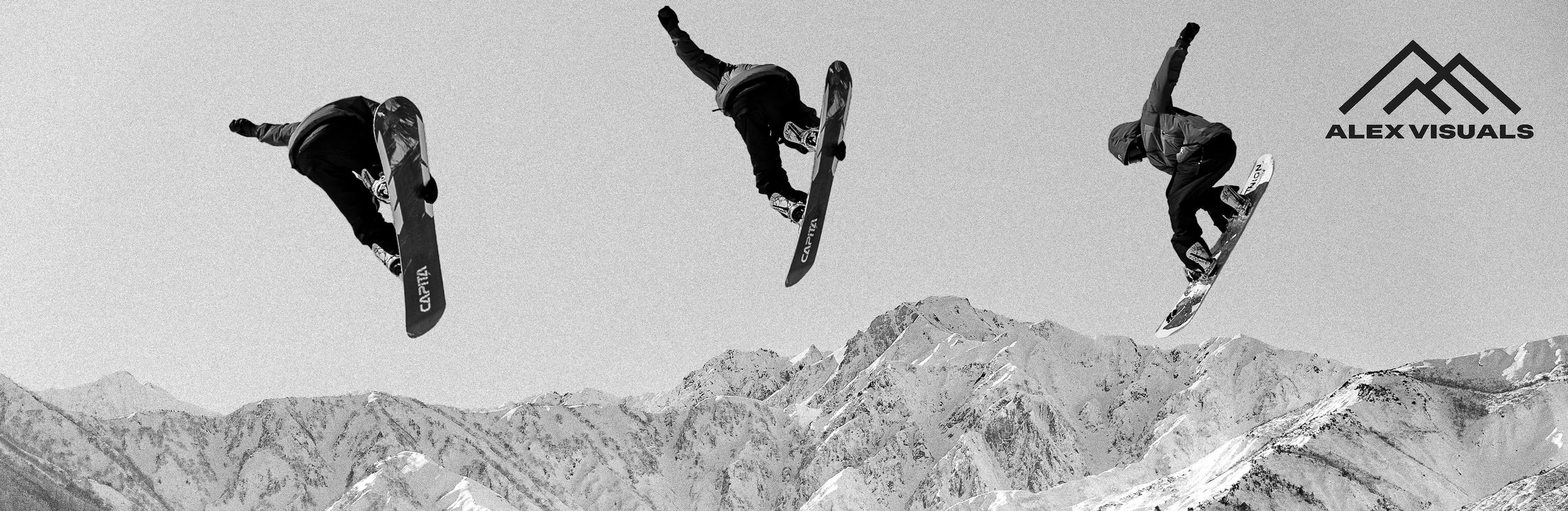 Black and white photograph of three snowboarders performing aerial tricks above a snow-covered mountain range. The snowboarders are in mid-air, facing downward. The top right corner features the logo and text 'ALEX VISUALS'.