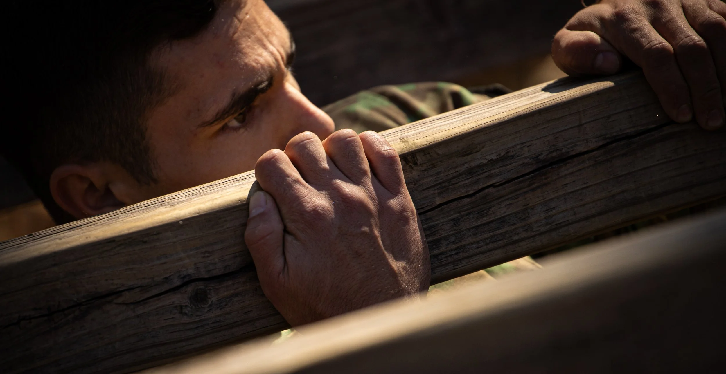 A person is holding a piece of wood and appears to be kissing or smelling it closely.