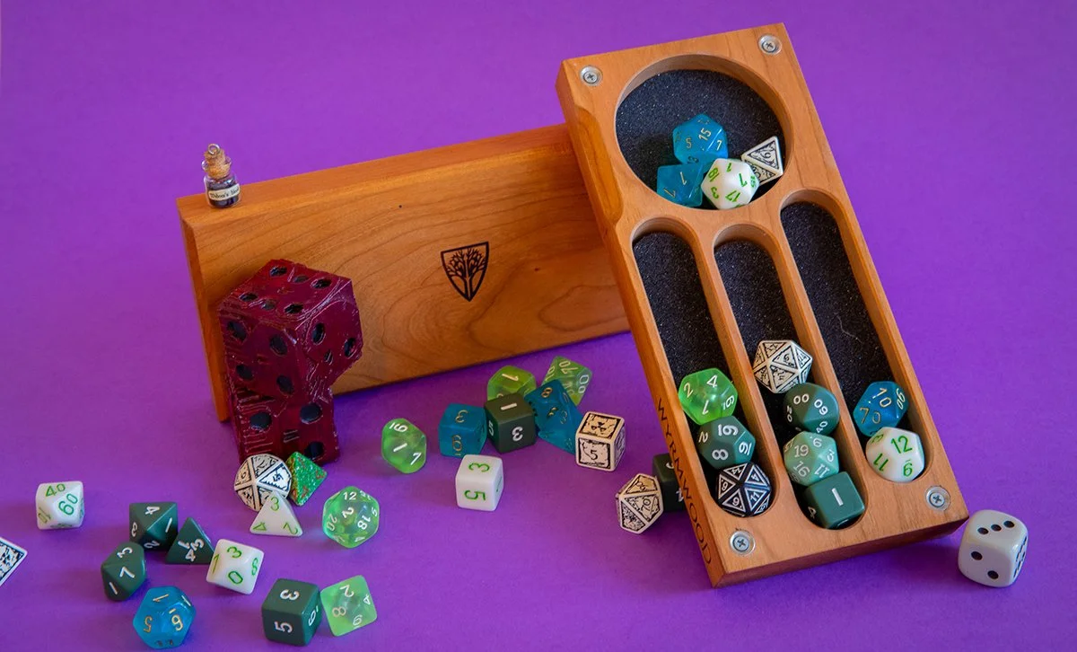 A variety of colorful polyhedral dice, a wooden dice holder, a red translucent die, a small bottle, and a six-sided die outside the holder on a purple background.