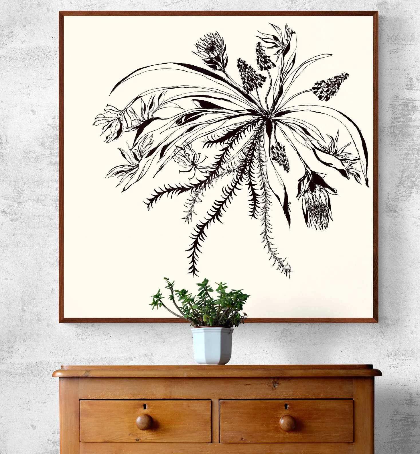 A black and white botanical line drawing on a large framed poster hangs on a wall. A small green plant in a white pot is positioned on a wooden sideboard beneath the poster.
