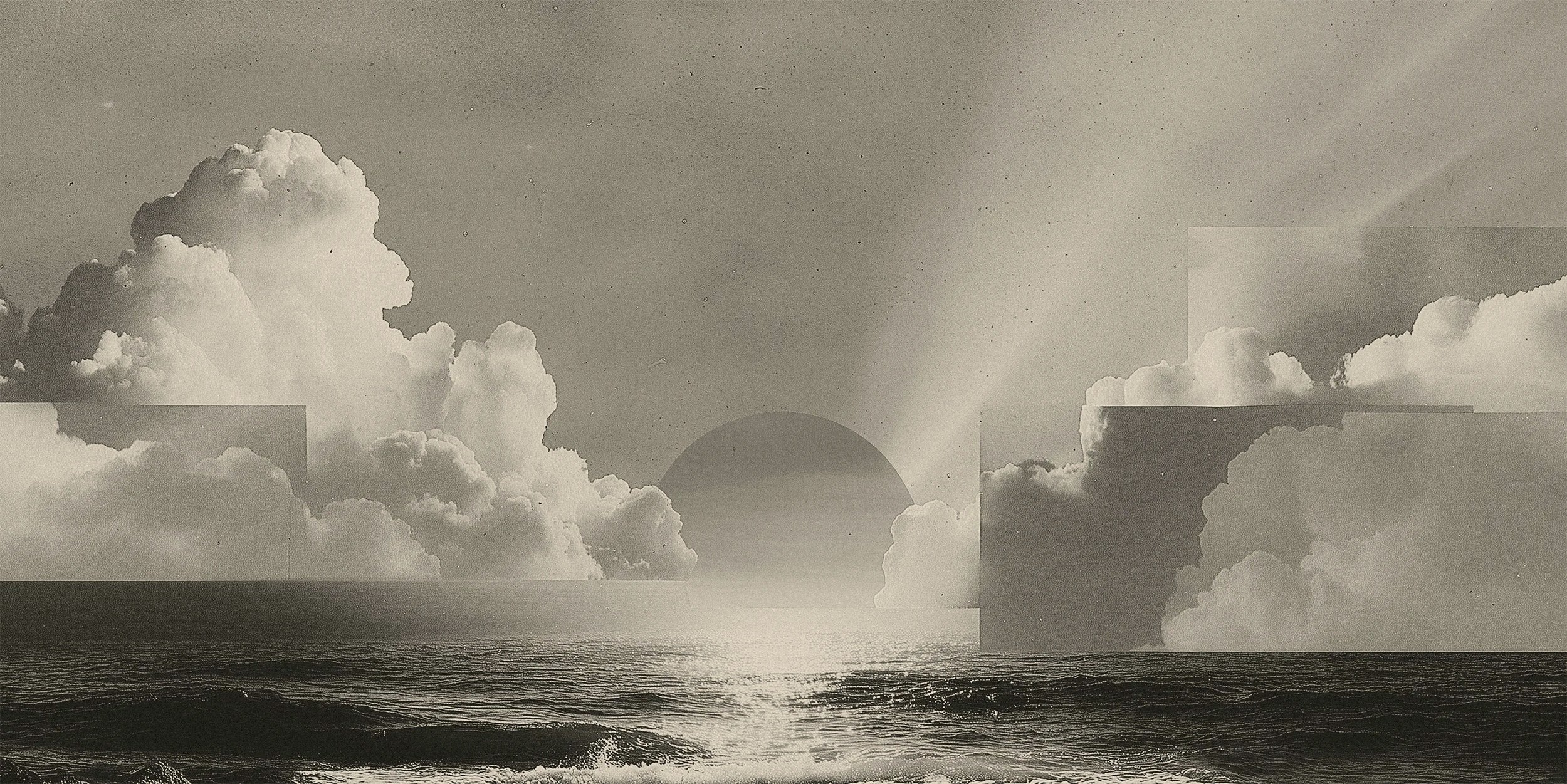 A black and white photo of a seascape with clouds and the sun near the horizon.