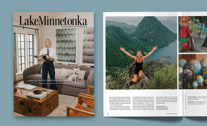 Open magazine titled 'Lake Minnetonka' on a blue surface, featuring a woman holding a magazine with a cat on a couch, and a two-page spread of a woman jumping with arms raised near a lake with mountains in the background, along with images of a colorful souvenir and decorated eggs.
