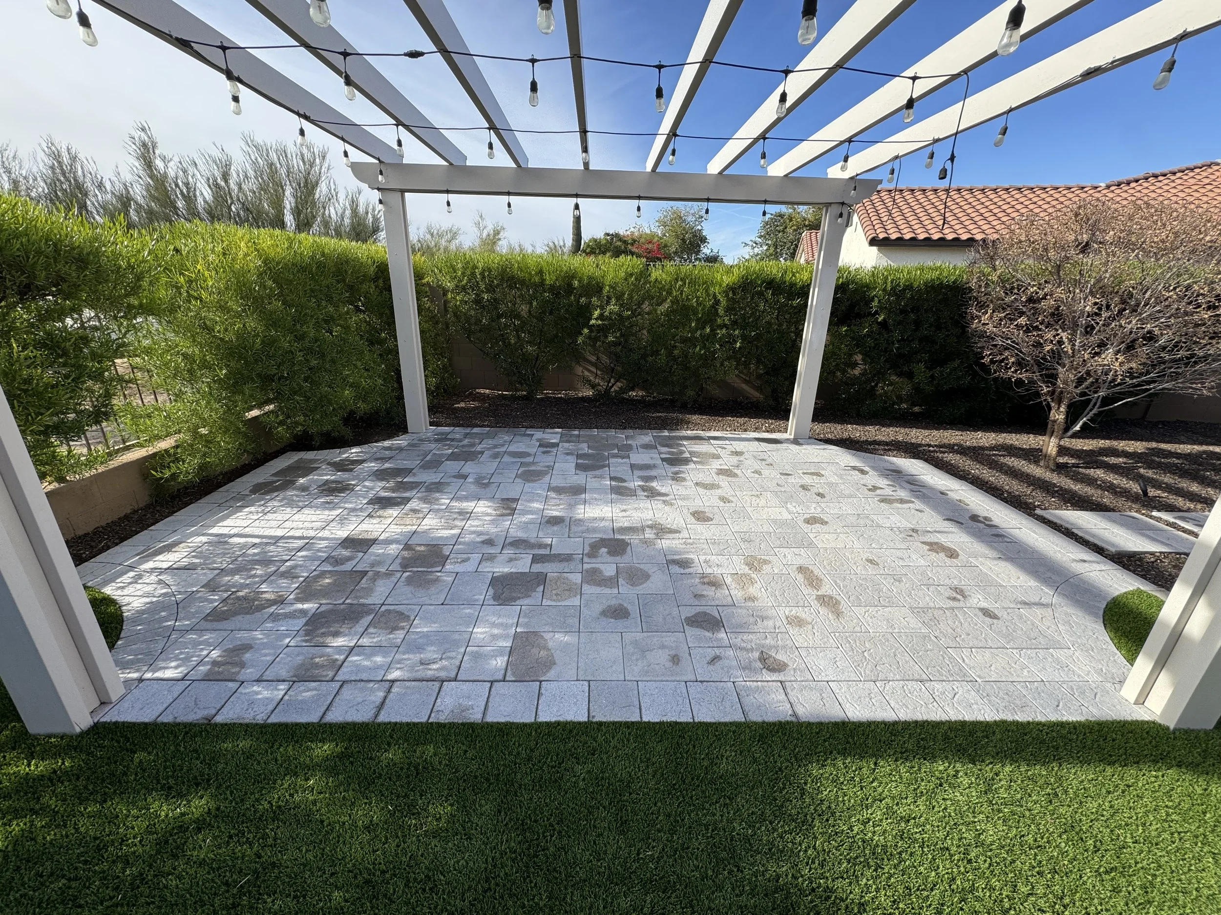 Backyard patio with gray and white tile flooring, quality hardscape for Arizona home landscape design, with expert-level construction and materials to enhance outdoor landscape and environment.