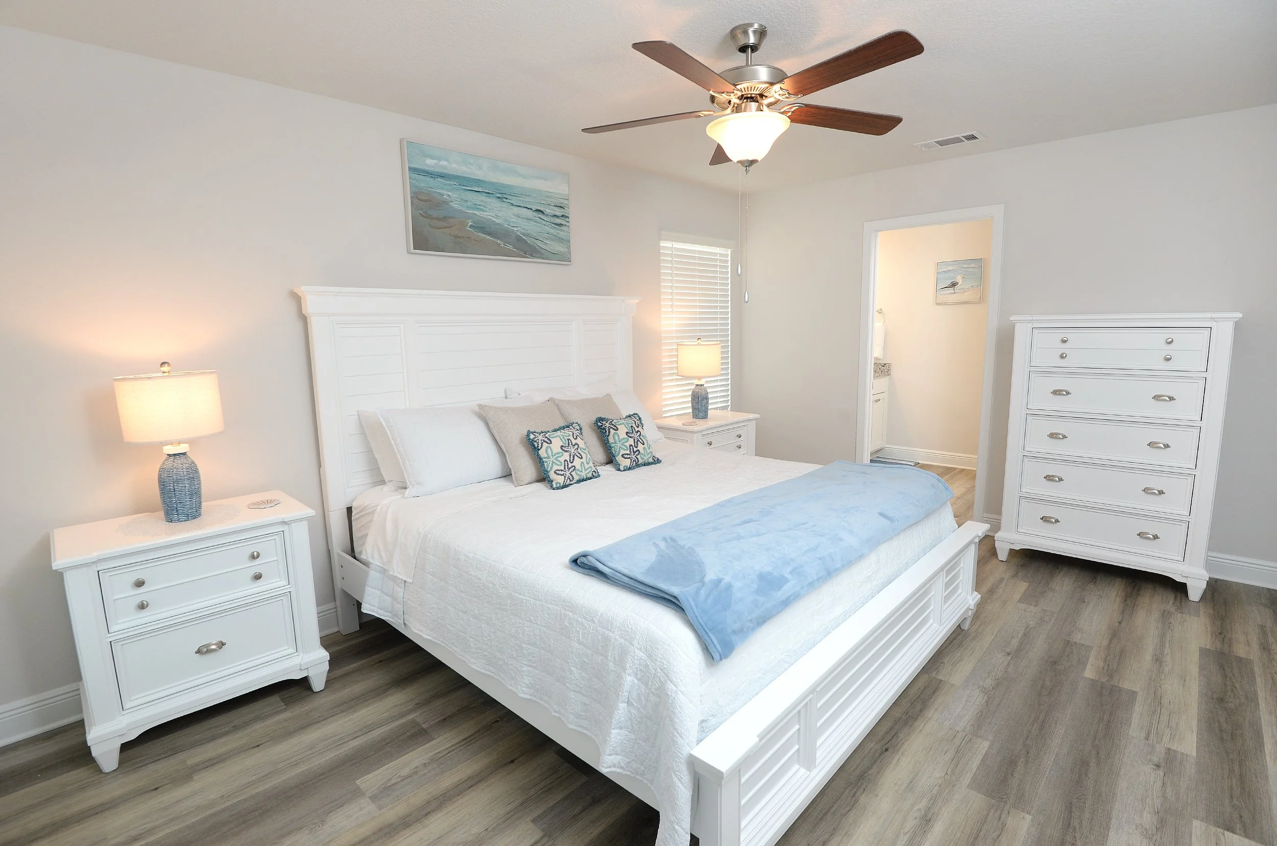 King size bed in master bedroom of Coastal Tide Escapes Panama City Beach vacation rental with ceiling fan and coastal decor