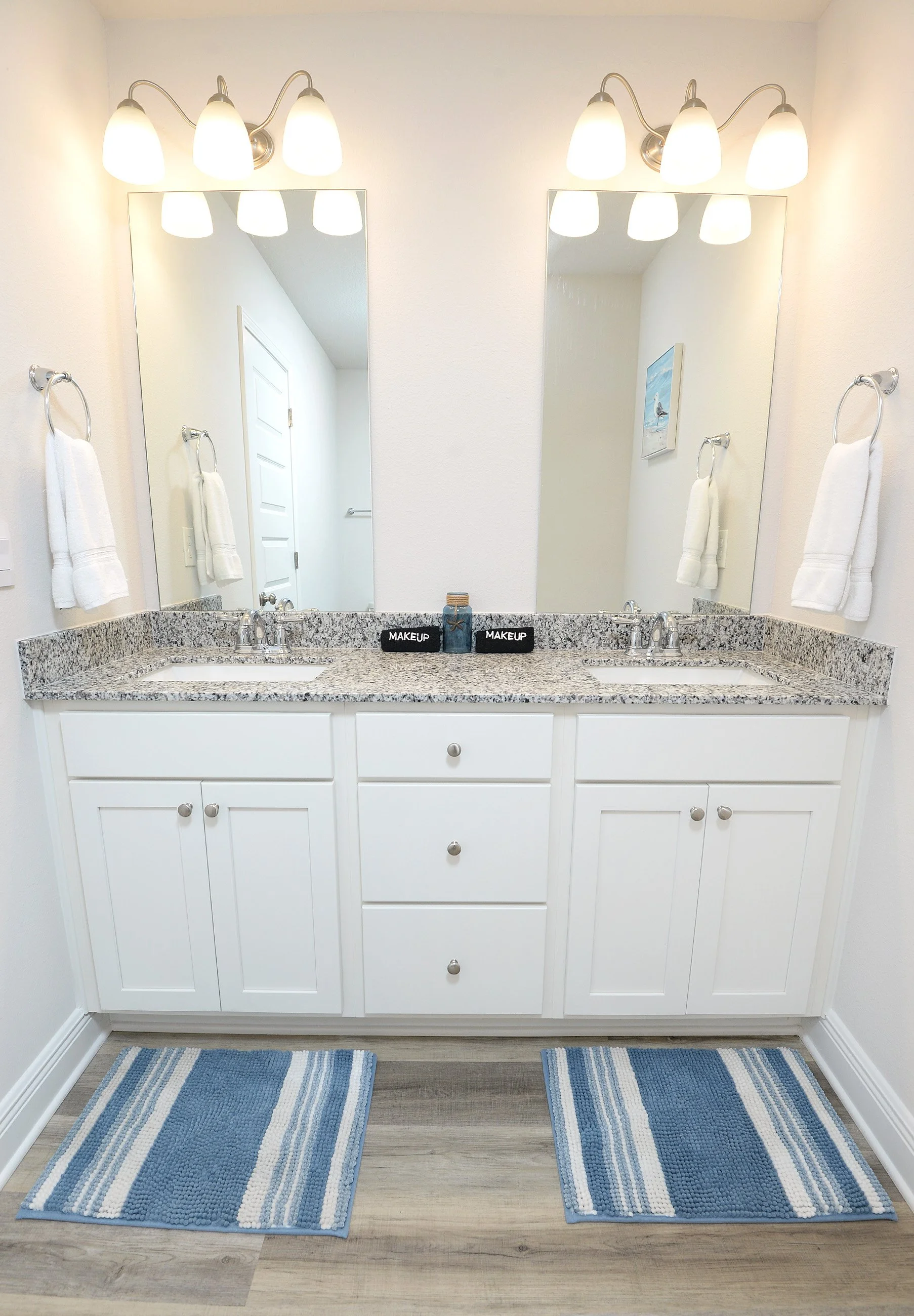 Master bath vanity and mirror at Coastal Tide Escapes Panama City Beach vacation rental with granite countertops and dual sinks