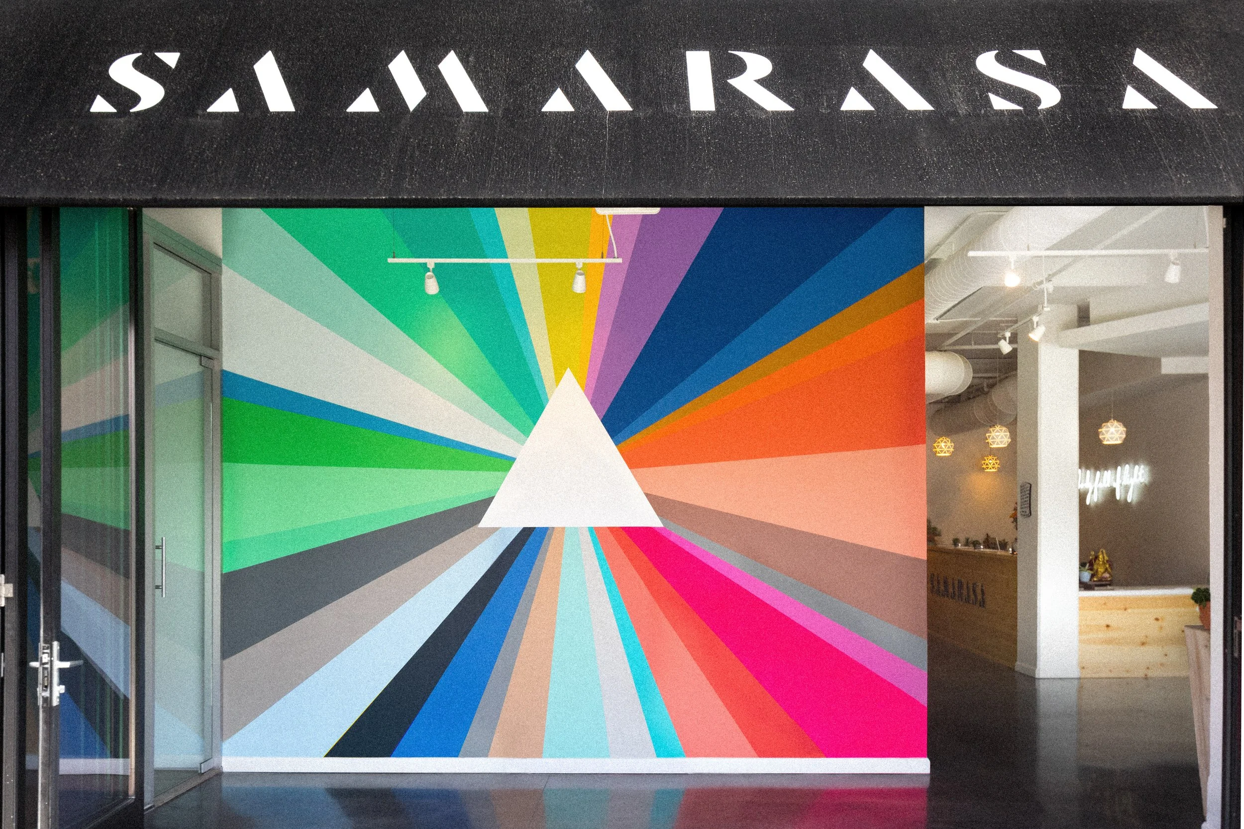 Colorful geometric mural with radiating bands inside Samarasa Yoga Studio in Los Angeles.