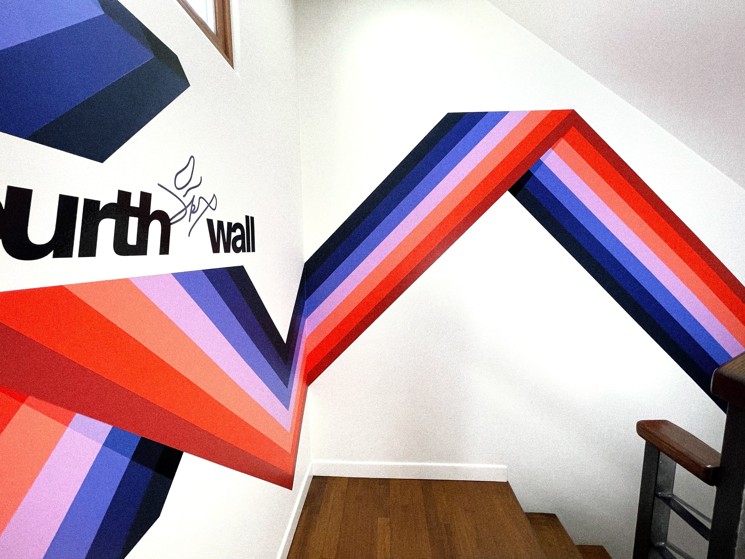 Red, coral, purple, and blue striped mural extending through the staircase of the Fourthwall office in Venice.