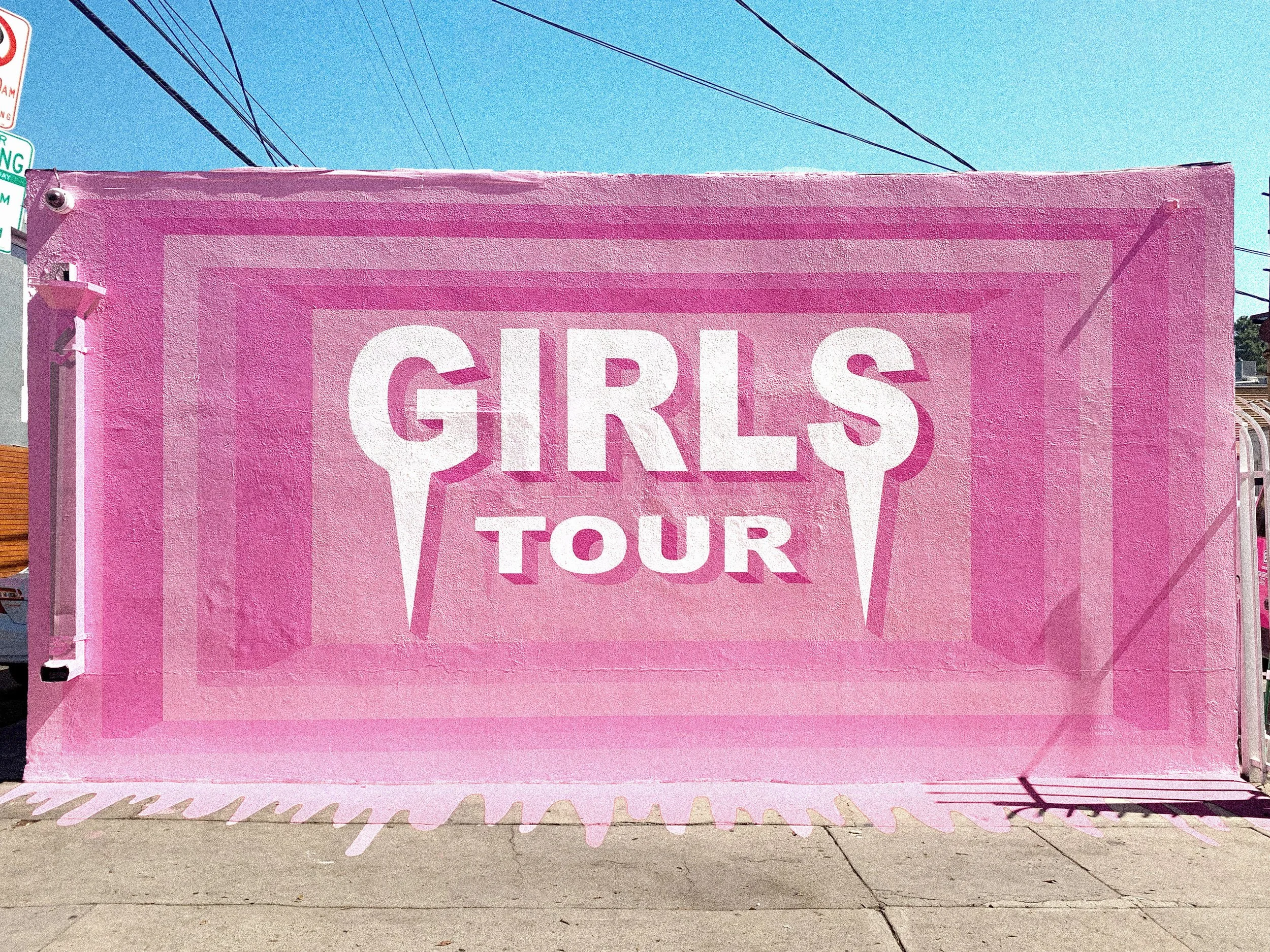 Pink Girls Tour exterior mural in West Hollywood, California, featuring layered geometric framing and oversized white lettering.