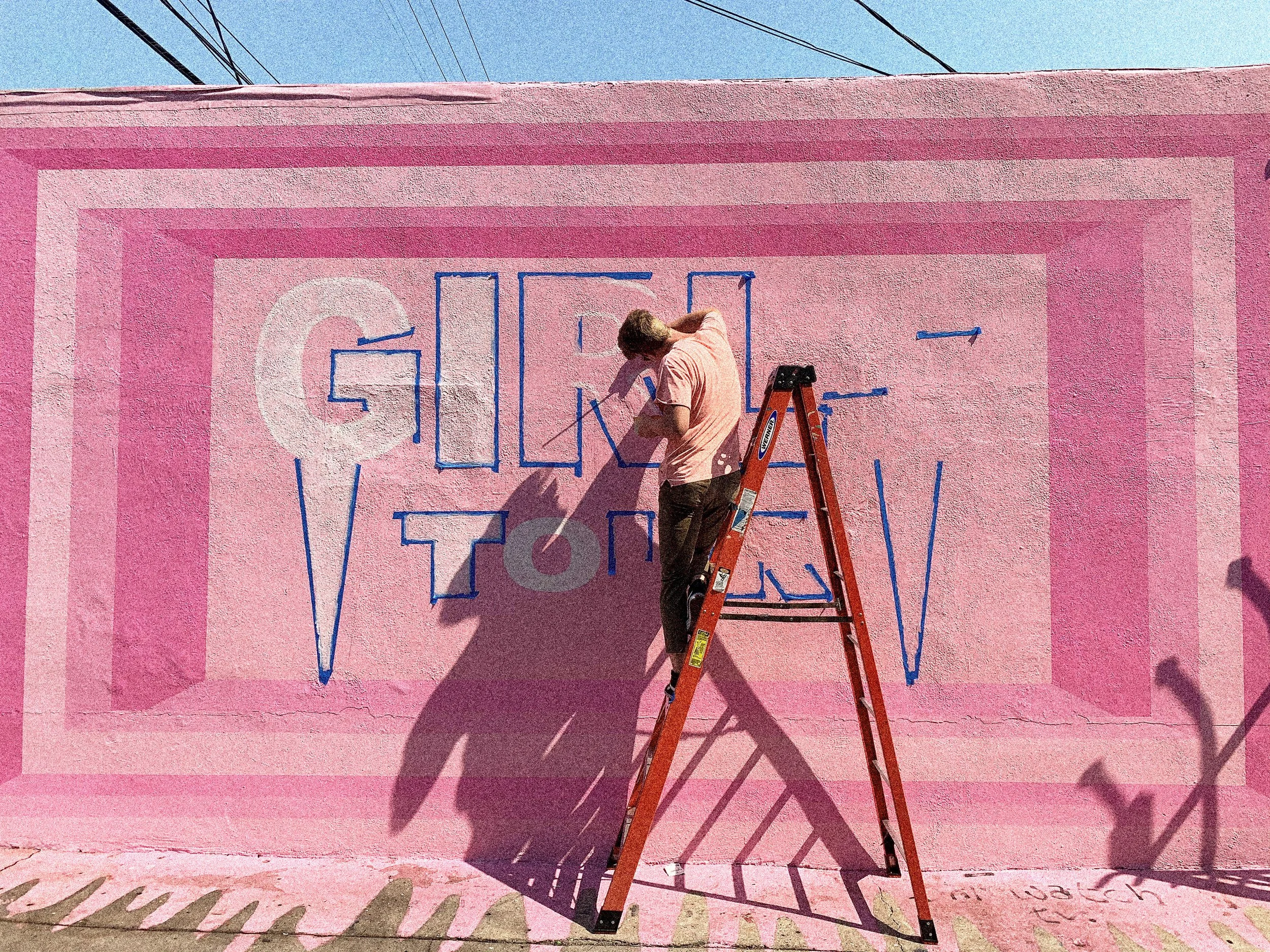 Installation process for the Girls Tour mural in West Hollywood with the geometric design mapped onto the exterior wall.