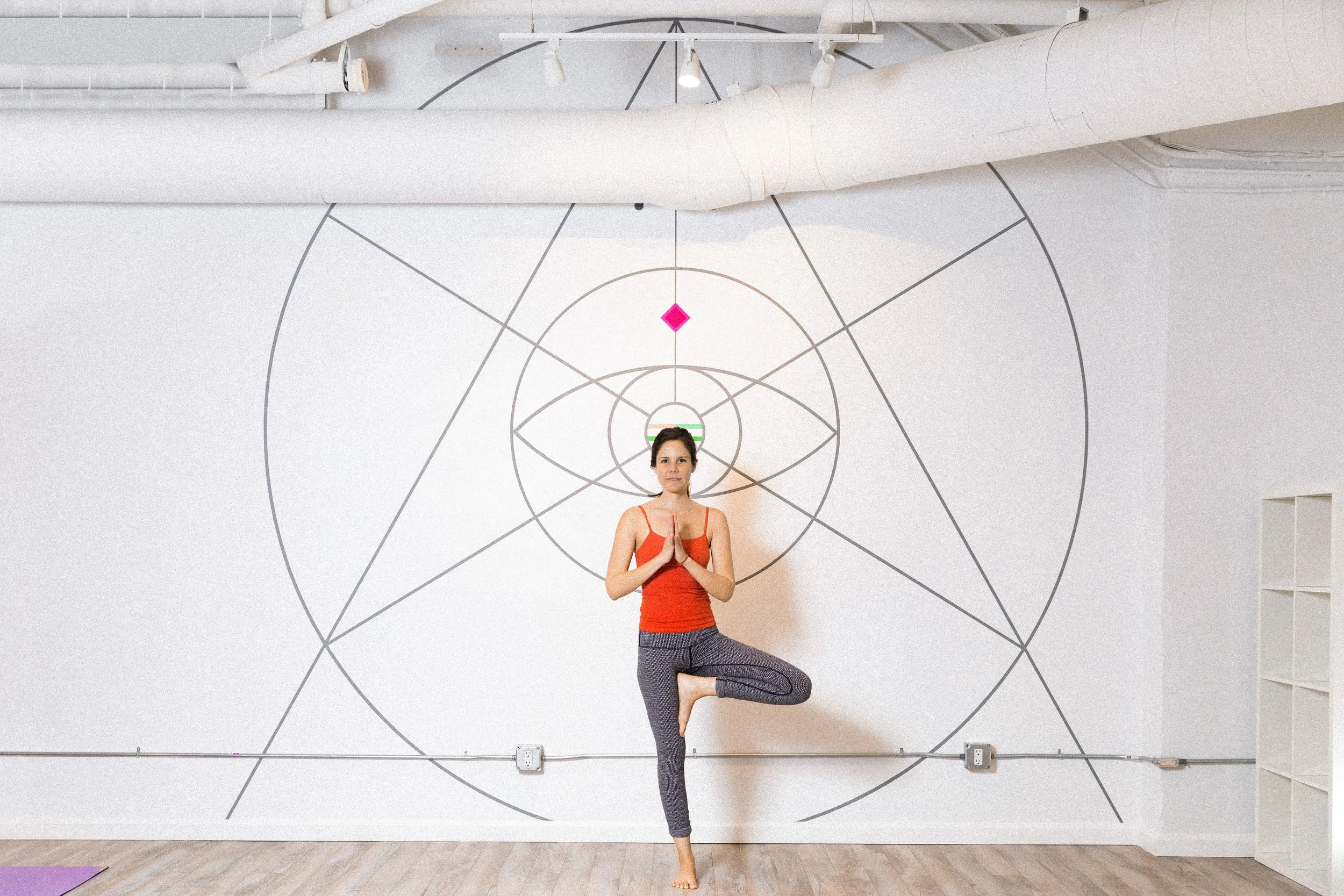 Yoga practitioner standing in front of a geometric line mural at Samarasa Yoga Studio in Los Angeles.