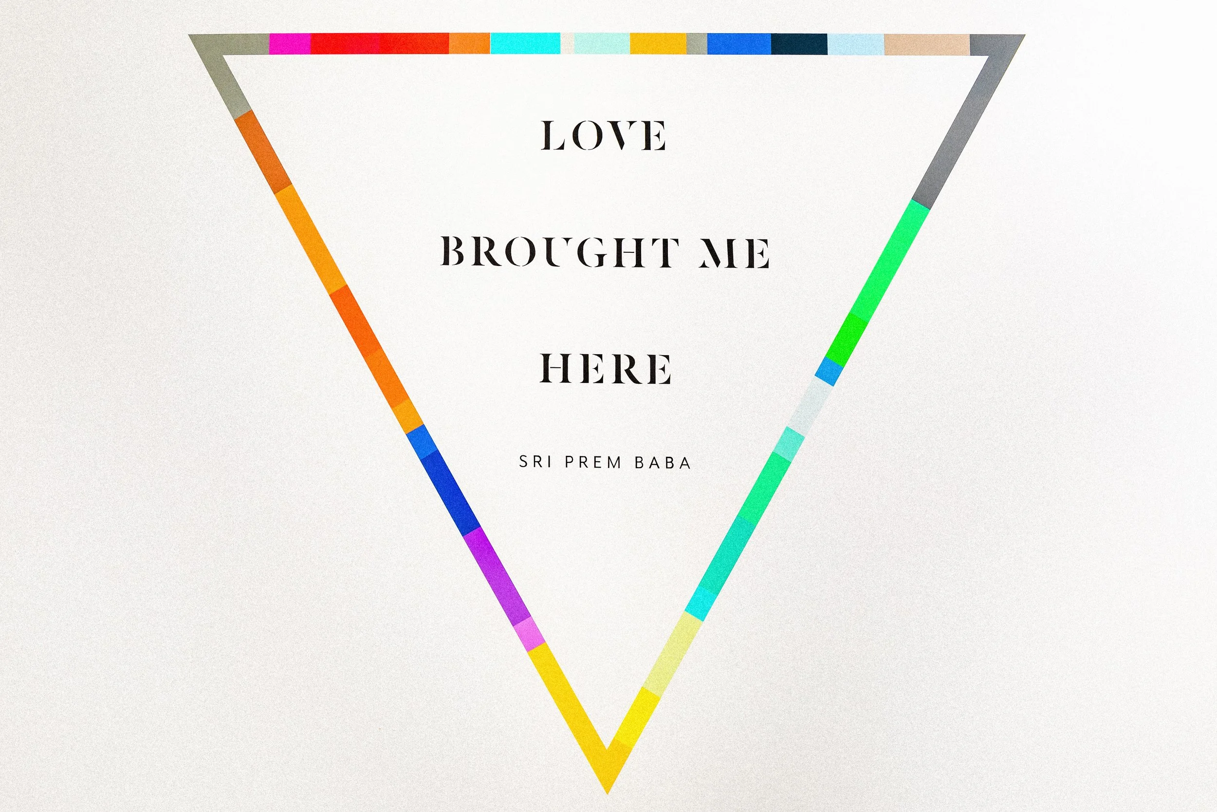 Love Brought Me Here typography mural framed by colorful geometric lines at Samarasa Yoga Studio.