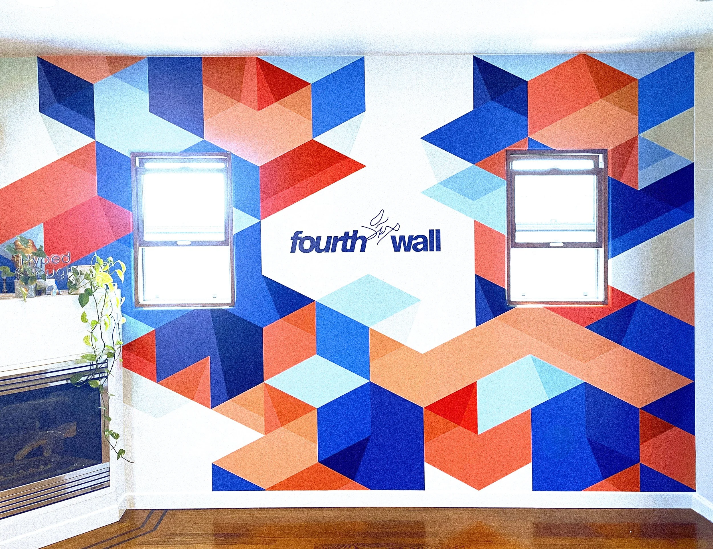 Geometric cube pattern mural surrounding the Fourthwall logo at the company’s Venice, California office.Geometric cube pattern mural surrounding the Fourthwall logo at the company’s Venice, California office.