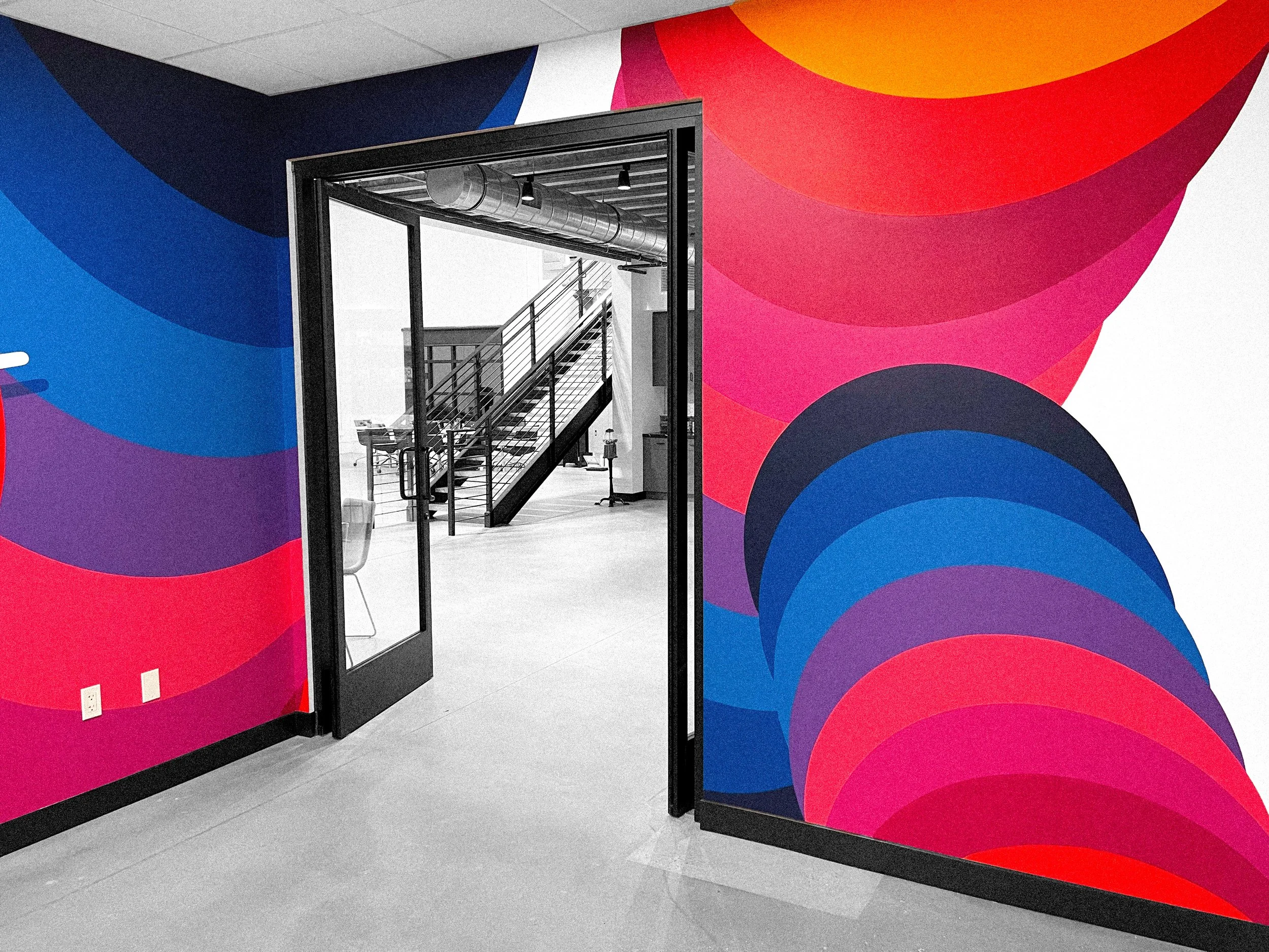 Faculty Inc. interior mural wrapping a doorway with colorful curved forms in Calabasas