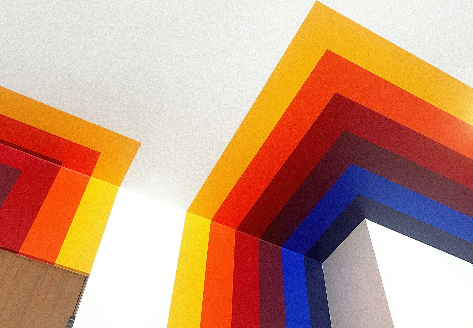 Colorful rainbow geometric wall mural by Andrew Haan for a private residential gym