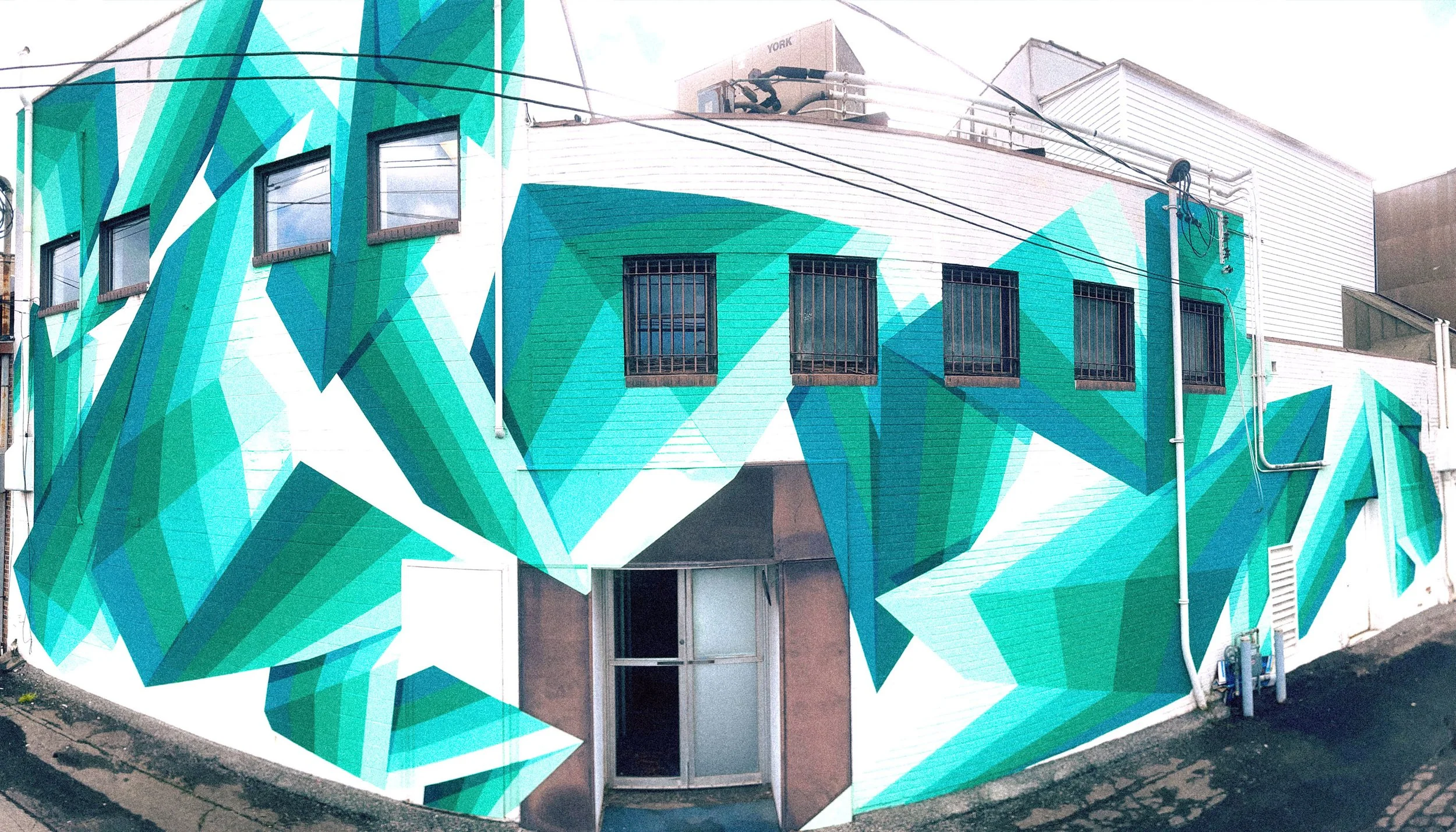 Large-scale geometric mural covering the exterior of a building in downtown Endicott, New York