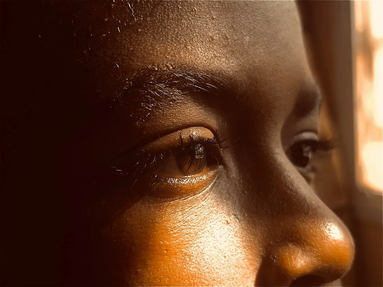 Close-up profile of a child’s face illuminated by warm sunlight