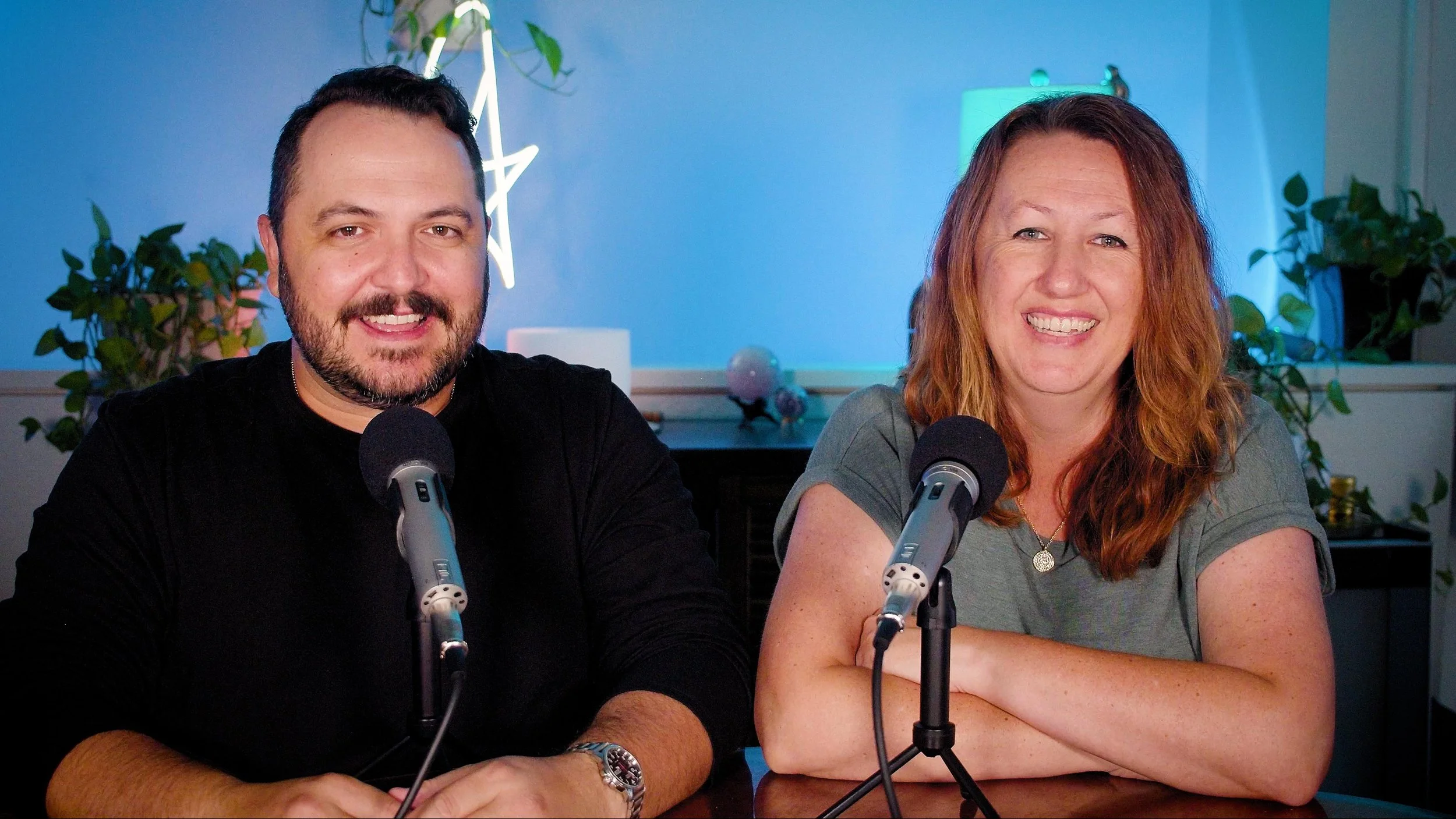 Frank and Lauren Leon seated at microphones while recording the Clairvoyaging podcast
