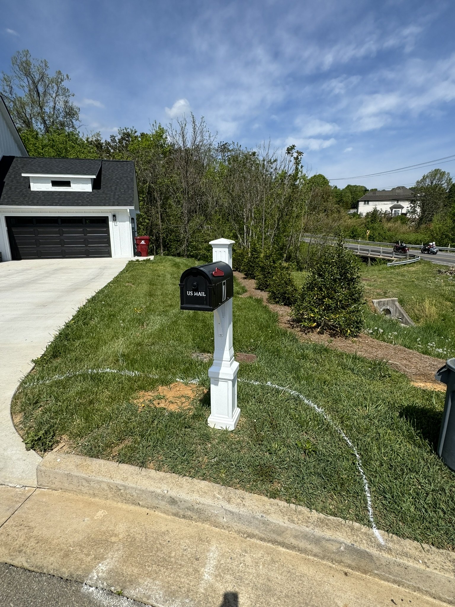 Custom mailbox landscape installation with shrubs and mulch designed to improve curb appeal and conceal utility equipment.
