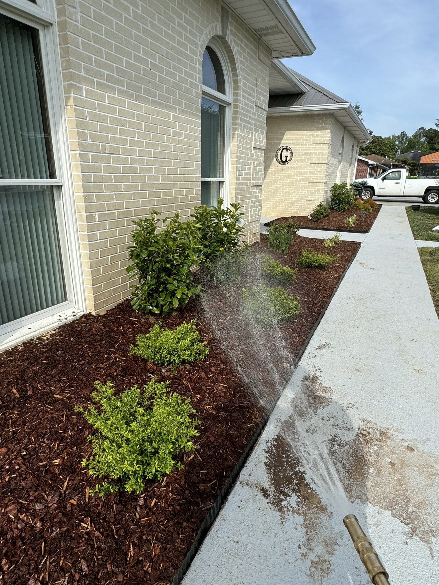 New landscape installation featuring shrubs, mulch, and clean bed edging designed to enhance the home's curb appeal.