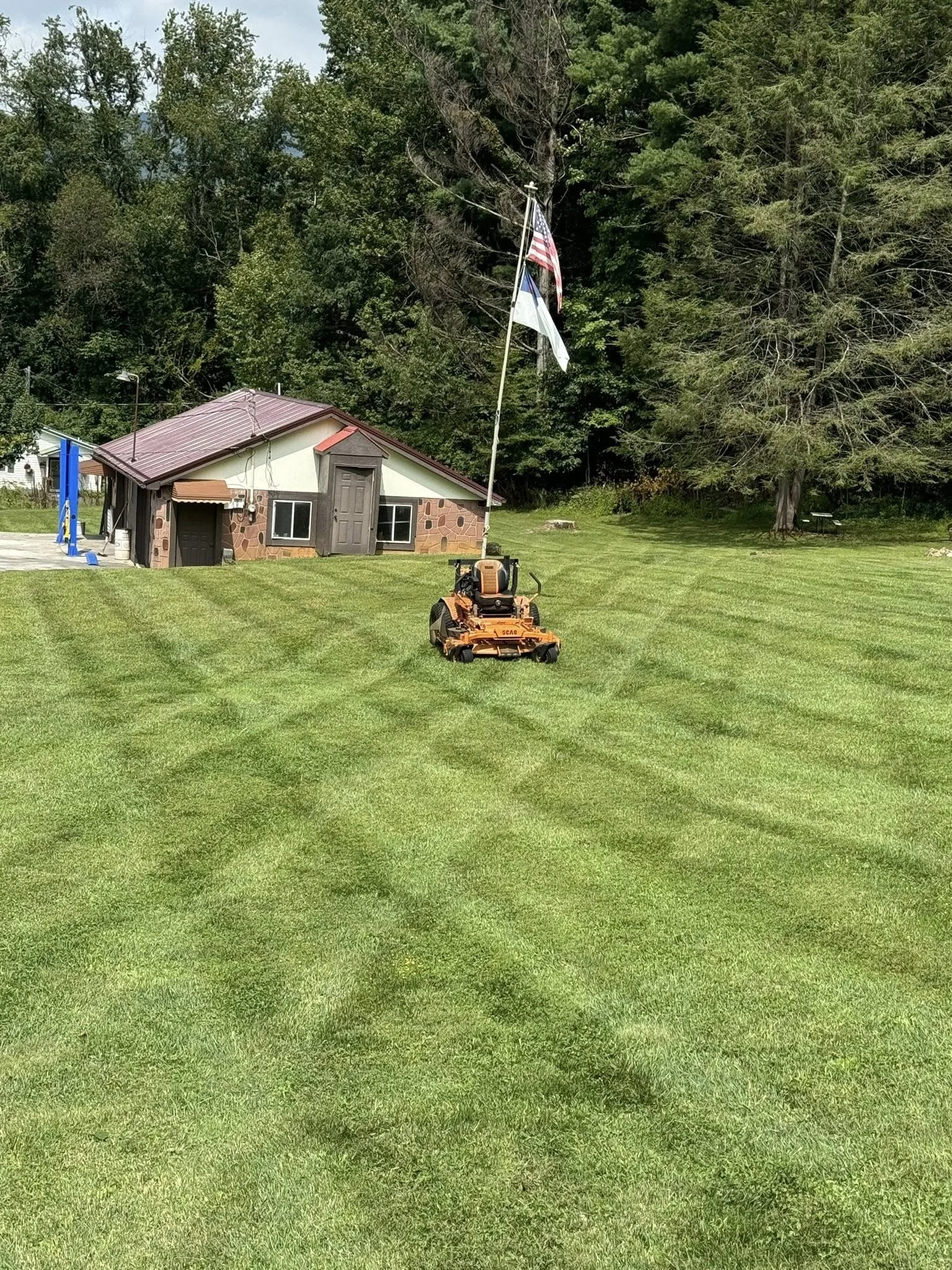 Freshly mowed lawn with professional striping completed by EarthWorks Landscaping as part of routine lawn maintenance services.