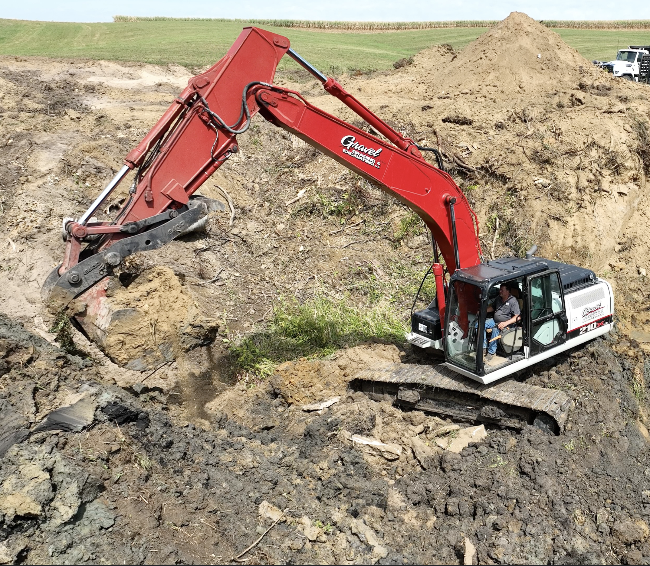 Gravel Grading & Excavating crew member, Rick, operating a branded Link-Belt excavator during active excavation work on an Eastern Iowa job site